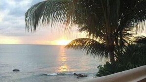 A balcony with a clear view of the ocean and a sunset. - Casa Sack Ocean Front apartment  (Rincon)