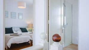 Une chambre à coucher avec un lit, des tables de chevet et une commode.
