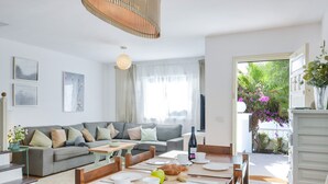 Un salon moderne avec un canapé, une table à manger et une vue sur un jardin.