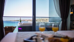 Un tavolo da pranzo con un vassoio di cibo e due bicchieri di succo d'arancia, con vista sulla città costiera.