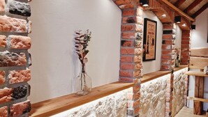 A rustic interior with exposed brick walls, wooden beams, and a stone accent wall. - Wirtshaus Zum Löwen (Steinenbronn)