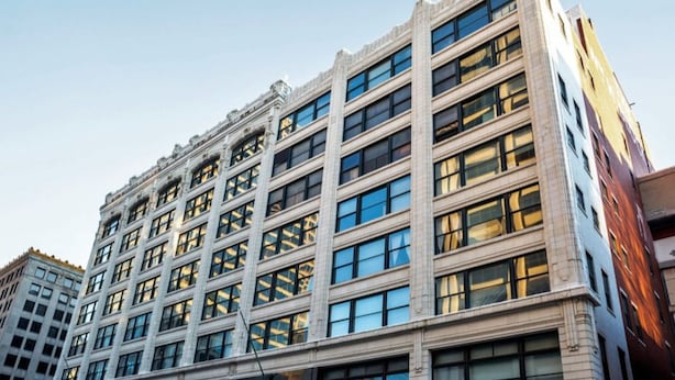 Un edificio a più piani con uno stile architettonico classico, caratterizzato da una facciata simmetrica con finestre regolarmente distanziate ed elementi decorativi nella parte superiore.