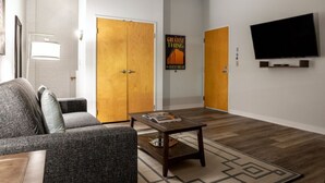 A modern living room with a sofa, coffee table, and a TV mounted on the wall. - Contemporary 2BR 2BA Apartment In Downtown Indianapolis by CozySuites (Indianapolis)