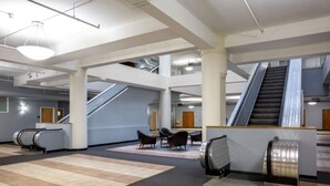 A spacious lobby with escalators, seating areas, and a modern design. - TWO Bold 2BR 2BA Apartments by CozySuites (Indianapolis)