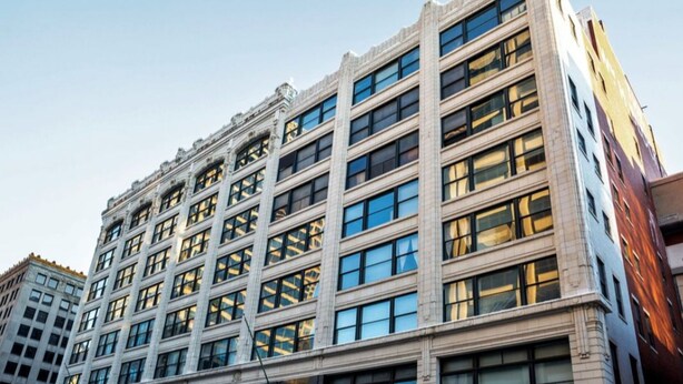 A multi-story building with a classical architectural style, featuring a symmetrical facade with large windows and decorative elements. - TWO Bold 2BR 2BA Apartments by CozySuites (Indianapolis)