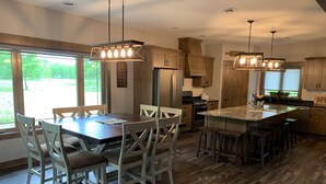 Une cuisine moderne avec des meubles en bois, un îlot central et des luminaires suspendus.