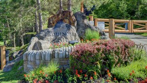 Un letrero de piedra con el nombre 'EQUINOX' rodeado por un jardín ajardinado con diversas plantas y flores.