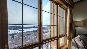 Una habitación con ventanas amplias que ofrecen vistas a un paisaje nevado y una masa de agua.