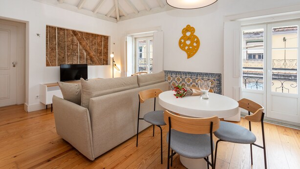 A cozy living room with a sofa, chairs, a TV, and a dining table. - Casas da Baixa - Jules & Madeleine (Lisbon)