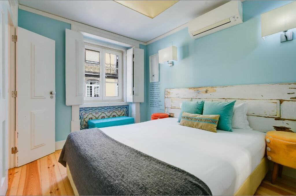 Une chambre à coucher avec un lit, une fenêtre, une porte et un appareil de climatisation.