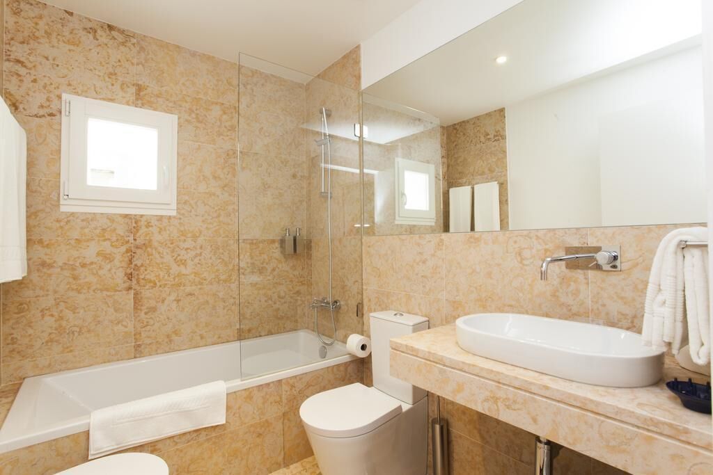 A modern bathroom with a bathtub, toilet, and sink.