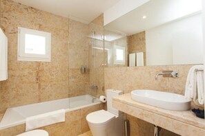 Un baño moderno con bañera, inodoro y lavabo.