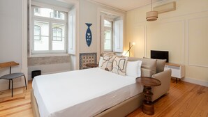 A bedroom with a large bed, a desk, a chair, and a TV. - Casas da Baixa - Jules & Madeleine (Lisbon)