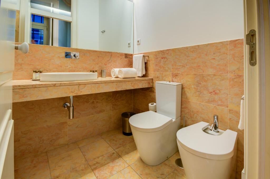 Ein Badezimmer mit Waschbecken, Toilette und Spiegel.