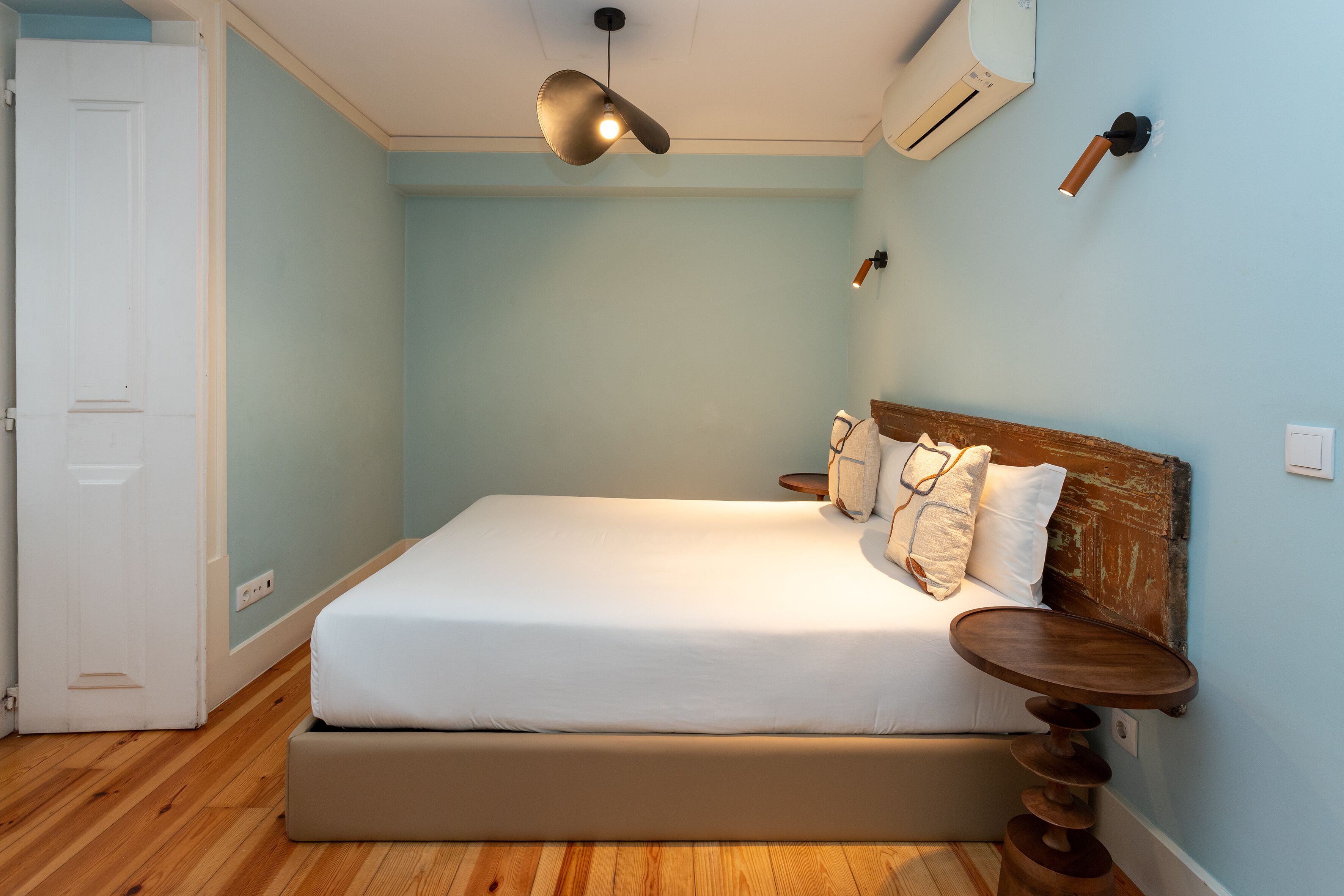 A bedroom with a bed, bedside tables, and a ceiling light.