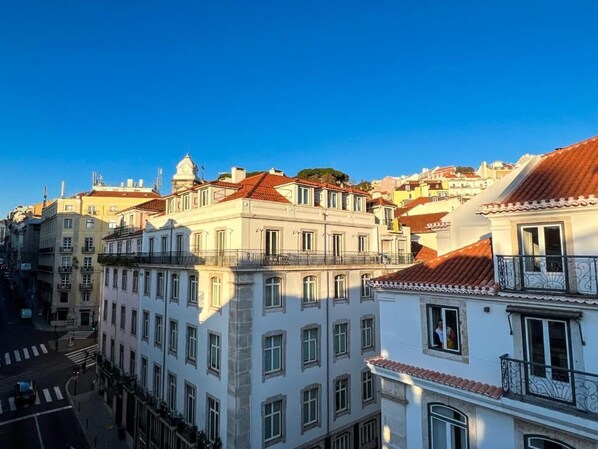 A cityscape with historic buildings featuring balconies and a clear blue sky.