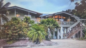 A modern building with multiple levels, large windows, and a staircase leading to the upper floors. - Beautiful Waterfront Large Private Gulfside Home Family Friendly.  (Marathon)