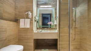 Ein modernes Badezimmer mit Toilette, Waschbecken, Spiegel und Dusche.