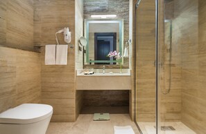 Un bagno moderno con il water, un lavandino, uno specchio e una doccia.