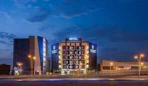 A modern hotel with a prominent 'HOTEL' sign, multiple floors, and a large entrance area.