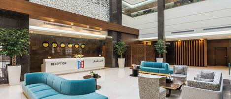 A modern reception area with a reception desk, seating arrangements, and decorative elements.