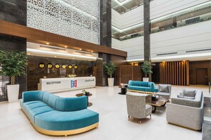 Un área de recepción moderna con mostrador, asientos y detalles decorativos.