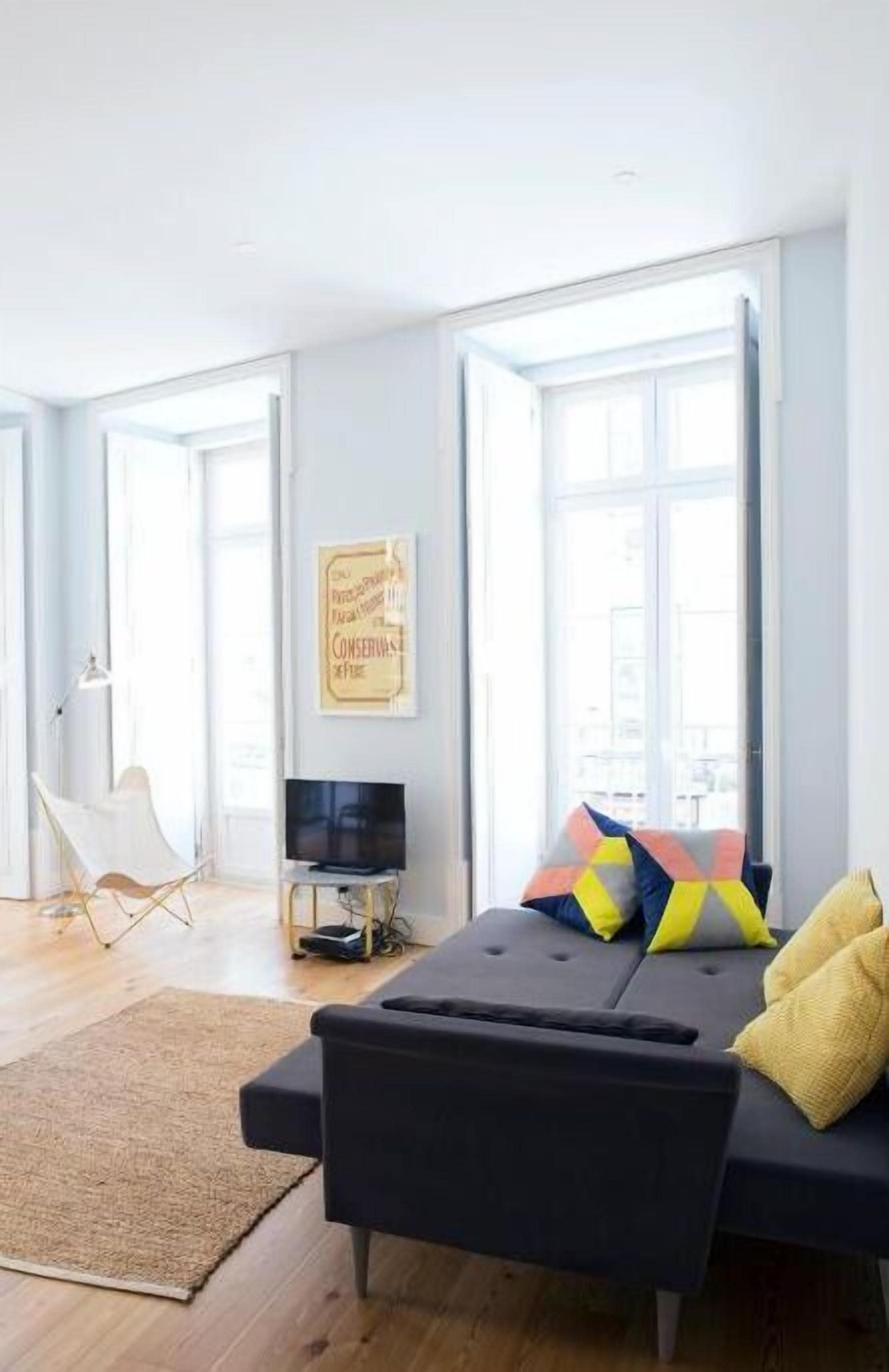 Ein modernes Wohnzimmer mit einer Couch, einem Fernseher und einem Teppich.