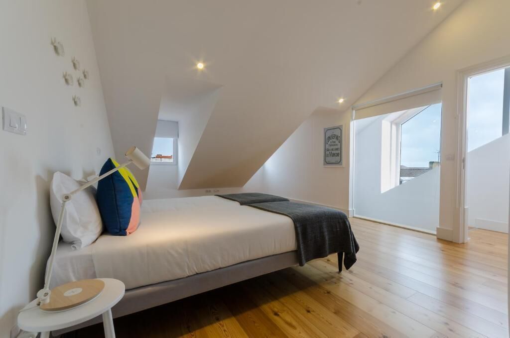 Une chambre à coucher avec un lit, une petite table et une fenêtre.