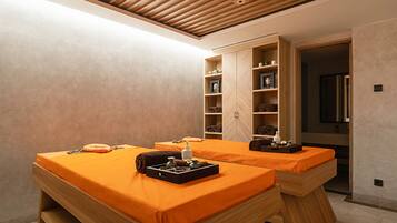 Relax in a serene spa room with two massage tables and a selection of spa amenities.