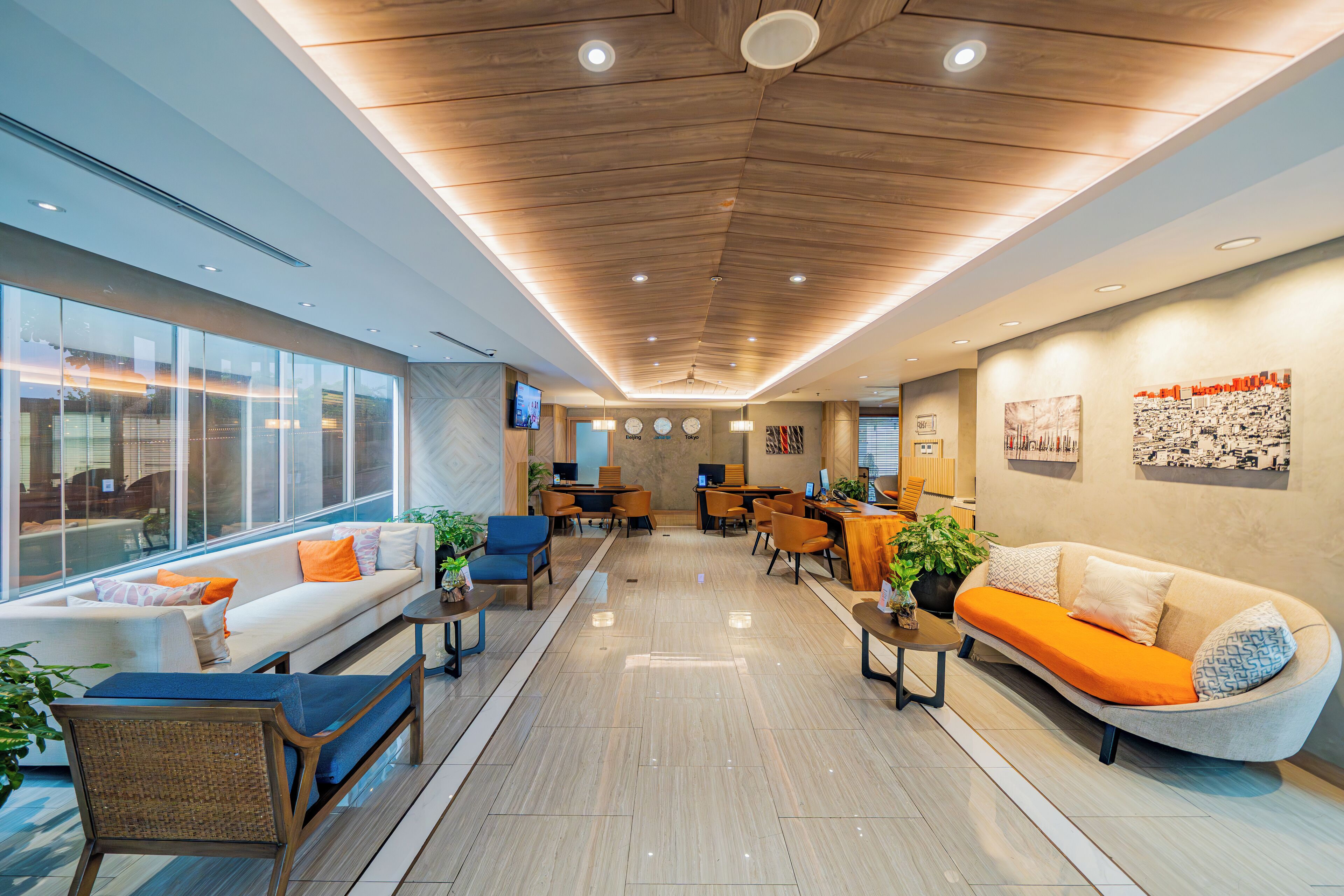 A modern lobby with a sofa, chairs, a coffee table, and a reception desk.