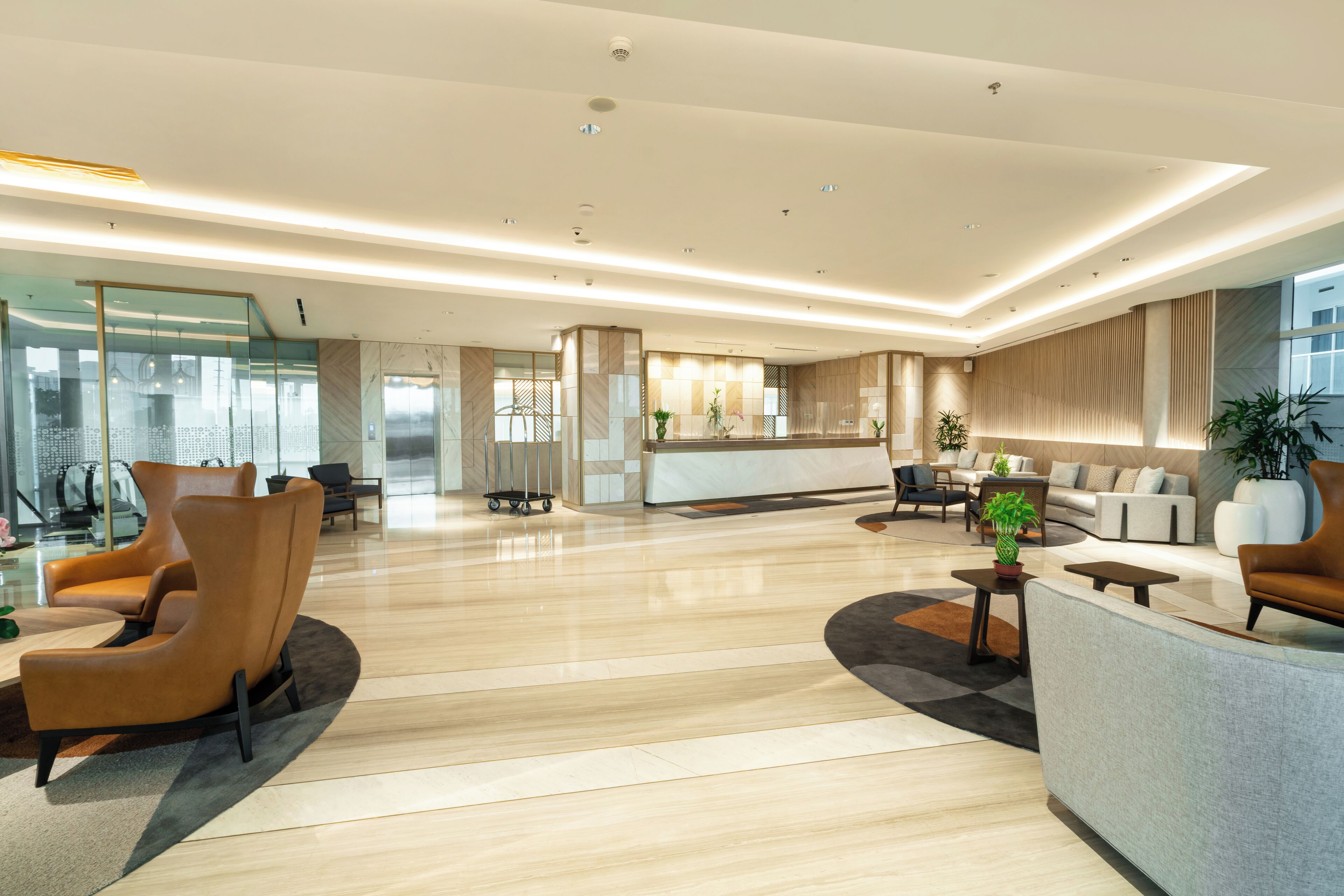A spacious lobby with a reception desk, seating area, and a modern design.