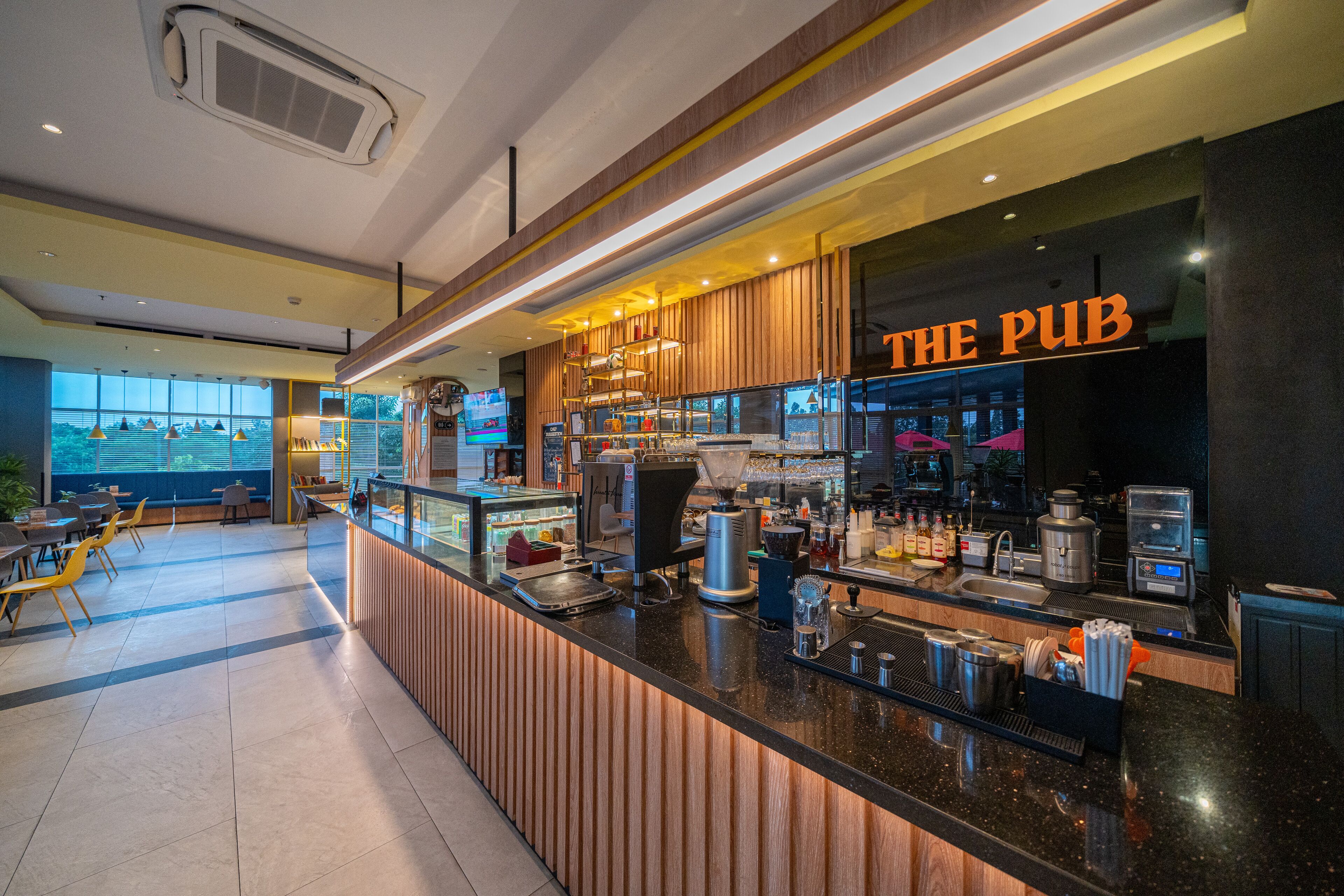 A modern bar area with a counter, bar stools, and a large window.