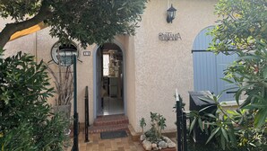 A building with a beige exterior, a blue door, and a sign reading "RITANA".