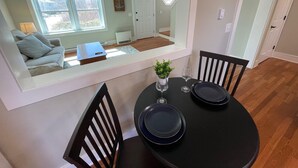 A dining area with a round table, two chairs, and a small potted plant. - Close to Pier and Downtown | Everything Included | Relax & Enjoy (Old Orchard Beach)