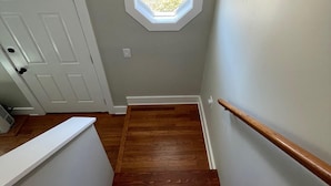 A staircase with wooden steps, a white handrail, and a small octagonal skylight. - Close to Pier and Downtown | Everything Included | Relax & Enjoy (Old Orchard Beach)