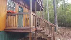 Eine Holzhütte mit Veranda und Treppe zu einer Terrasse.