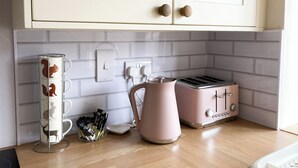 Un comptoir de cuisine avec une machine à café, un grille-pain et un porte-tasses.