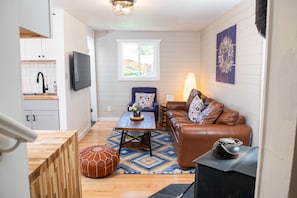 Una sala de estar con sofá, mesa de centro, chimenea y televisor.