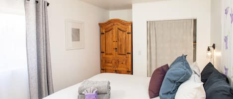 2 habitaciones, escritorio y tabla de planchar con plancha