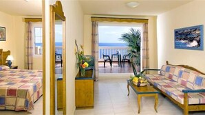 A hotel room with two beds, a balcony with a view, and a dining area. - Hotel Las Olas (Brena Baja)