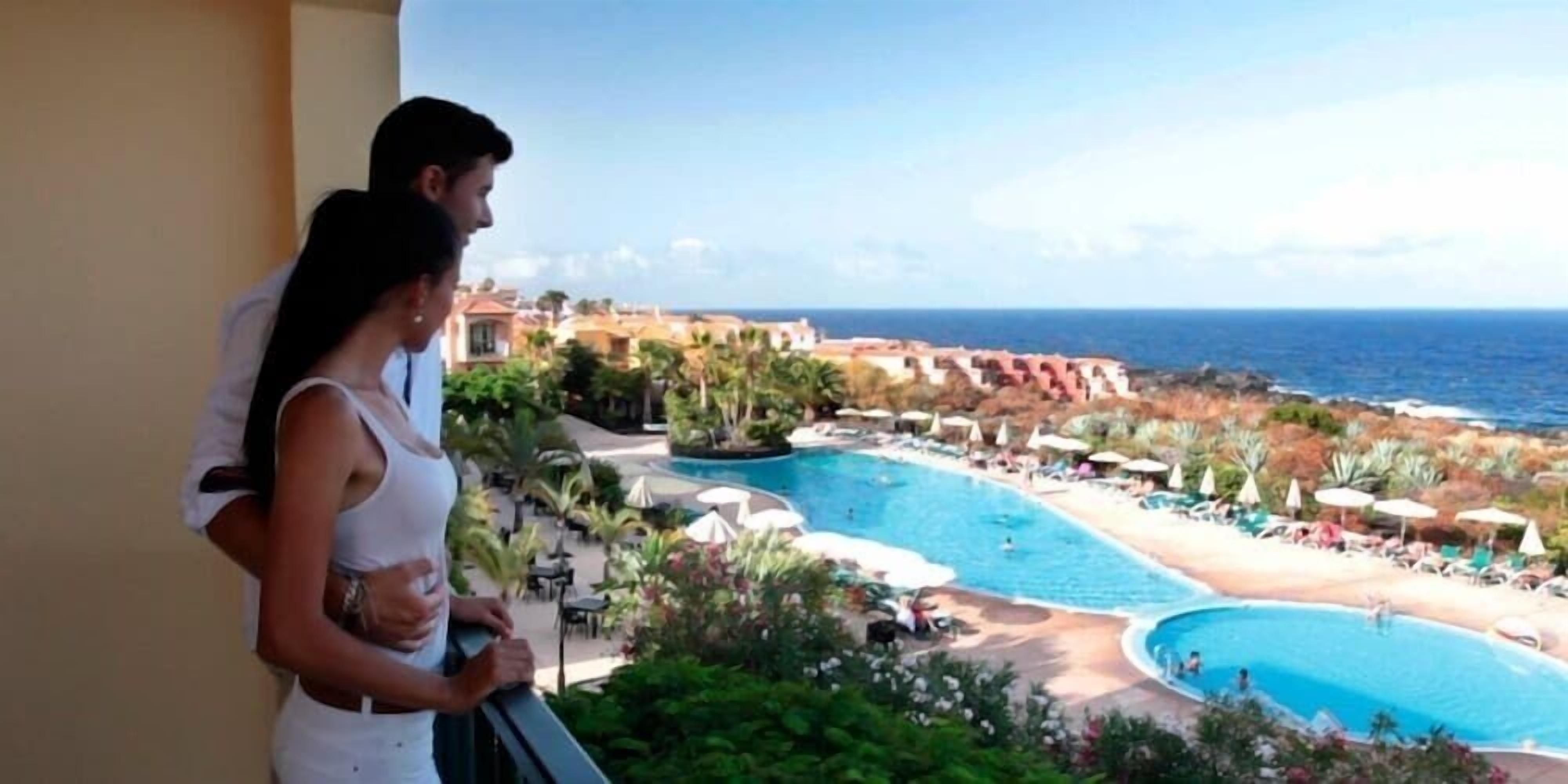 A resort with a large pool, beach area, and ocean view.