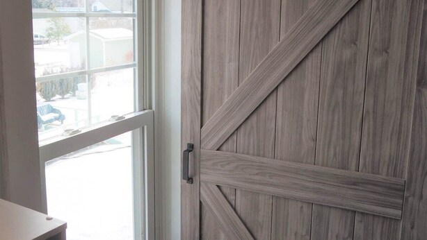 Una habitación con un ventanal grande y una puerta de madera estilo granero.