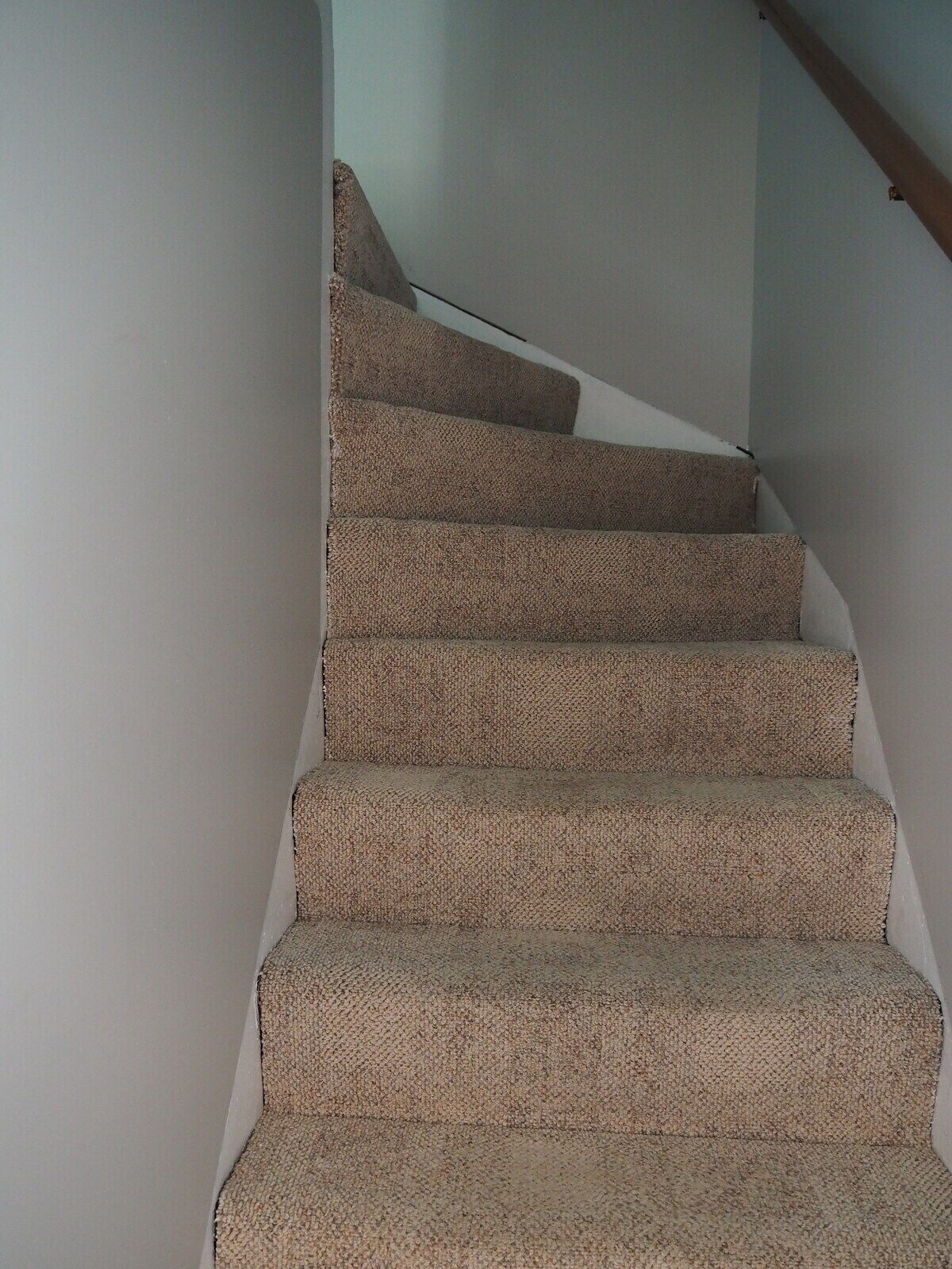 Una escalera con alfombra y barandilla de madera.