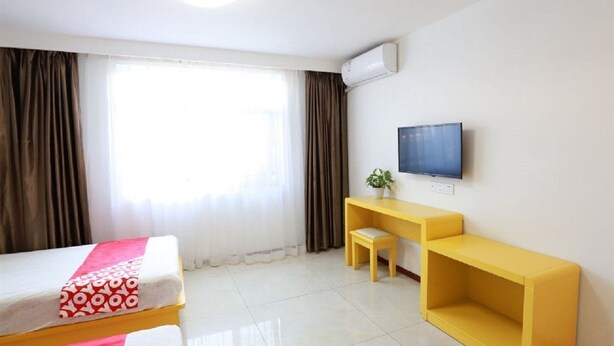 A hotel room with a bed, a desk, a chair, a TV, and a window with curtains. - Beijing Bincheng Hotel (Tongzhou)