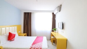 A hotel room with a bed, a desk, a chair, a TV, and a window with curtains. - Beijing Bincheng Hotel (Tongzhou)