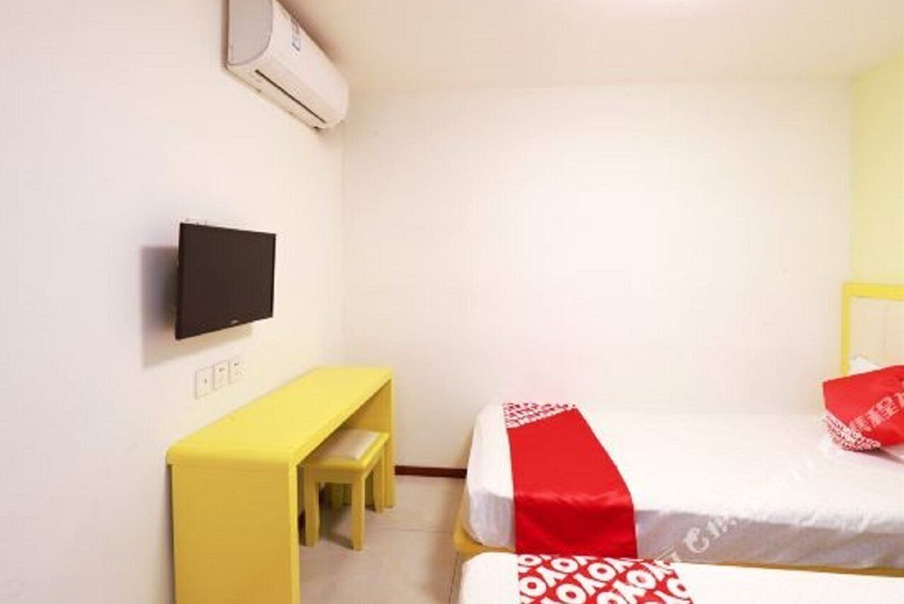 A small, clean room with a bed, a desk, and a TV.
