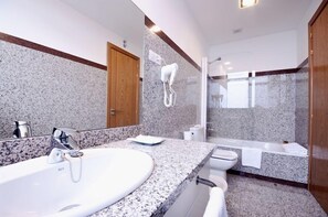 A modern bathroom with a granite countertop, a large sink, a toilet, and a bathtub. - Santiago (Lugo)