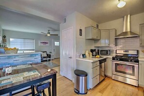 A kitchen with a stainless steel stove, microwave, and white cabinets.