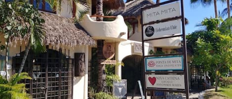 Un edificio con letreros que dicen 'MITAMITA Bohemian Chic' y 'PUNTA DE MITA Yoga y Pilates'.