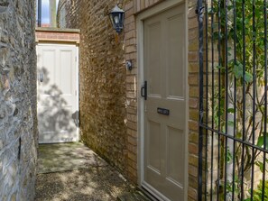 A narrow alleyway with a stone wall, a metal gate, and a beige door labeled "APPLE LOFT". - 1 bedroom accommodation in Nordham, near Beverley (Nordham, near Beverley)